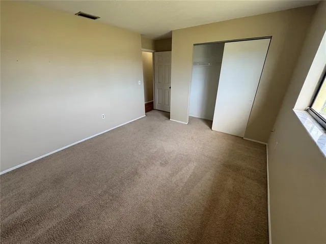 an empty room with closet and mirror