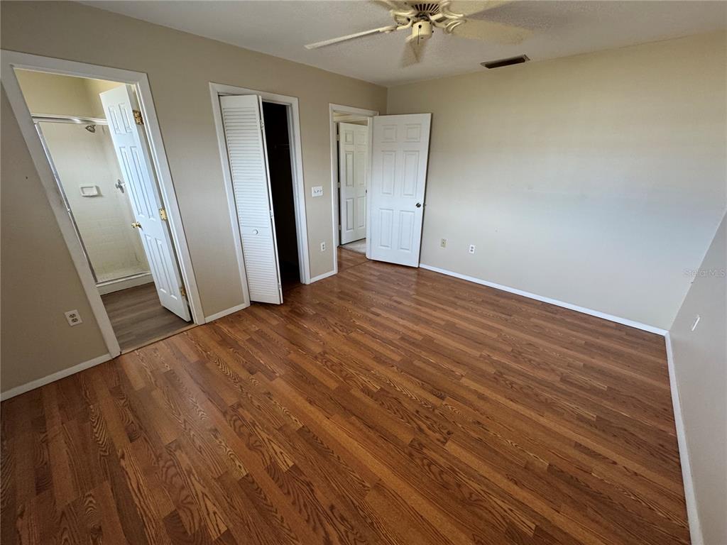 1786 Dagon Road Venice, FL 34293 - Photo 14 of 18 an empty room with wooden floor and fan
