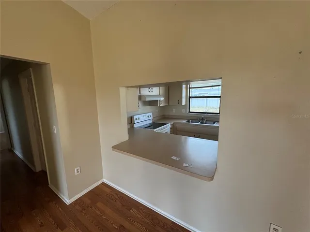 a kitchen with granite countertop white cabinets and refrigerator