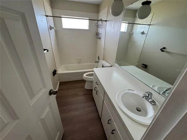 a bathroom with a tub sink a mirror and shower