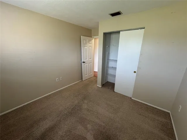 an empty room with closet and mirror