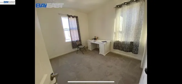 a bedroom with a bed and a refrigerator