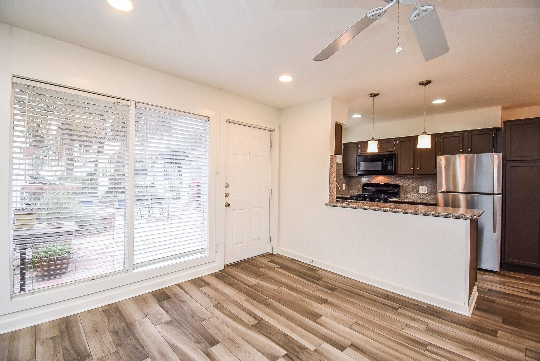 1404 Welch Street, Unit 2 Houston, TX 77006 - Photo 7 of 20 Open-concept living and dining area filled with natural light and wood-look flooring, offering an ideal space for everyday living and entertaining.