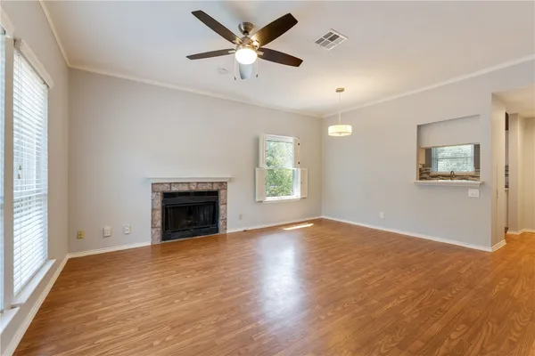 an empty room with windows and fireplace