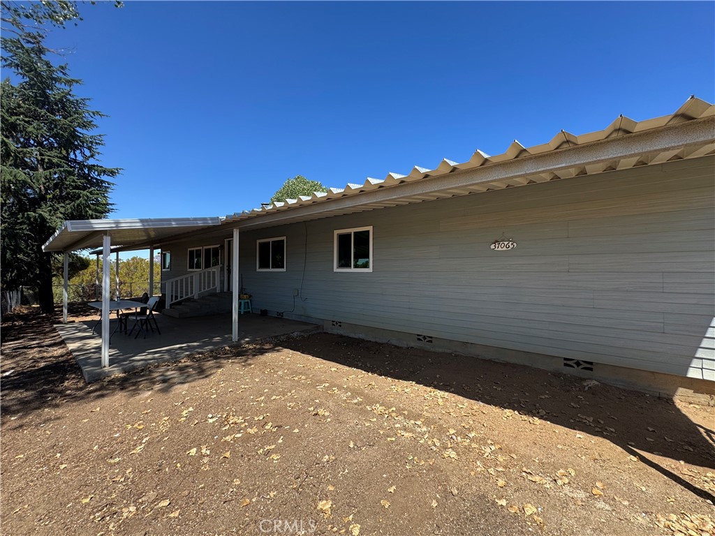 37065 Bonita Vista Road Anza, CA 92539 - Photo 2 of 65 a backyard of a house with table and chairs under an umbrella