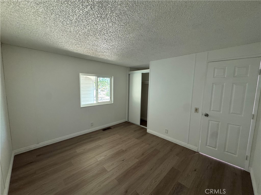 37065 Bonita Vista Road Anza, CA 92539 - Photo 24 of 65 a view of an empty room with wooden floor and a window