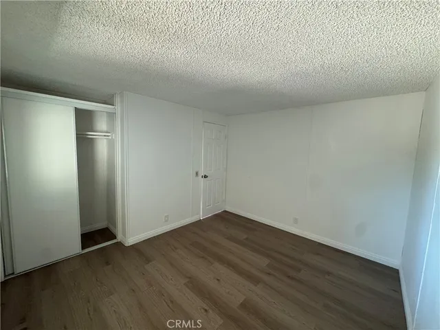 an empty room with wooden floor and closet