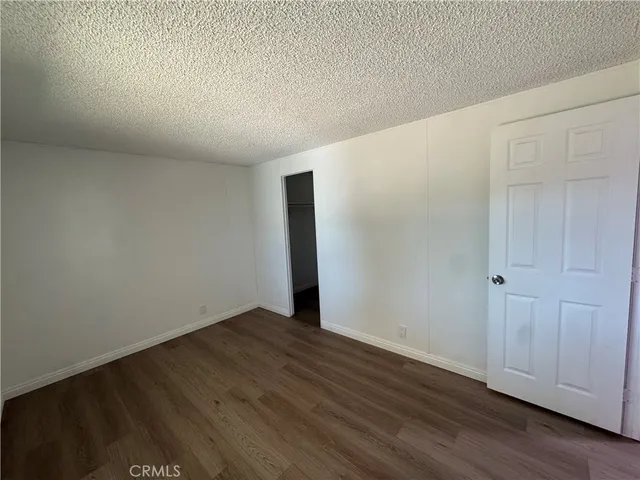 an empty room with wooden floor and window