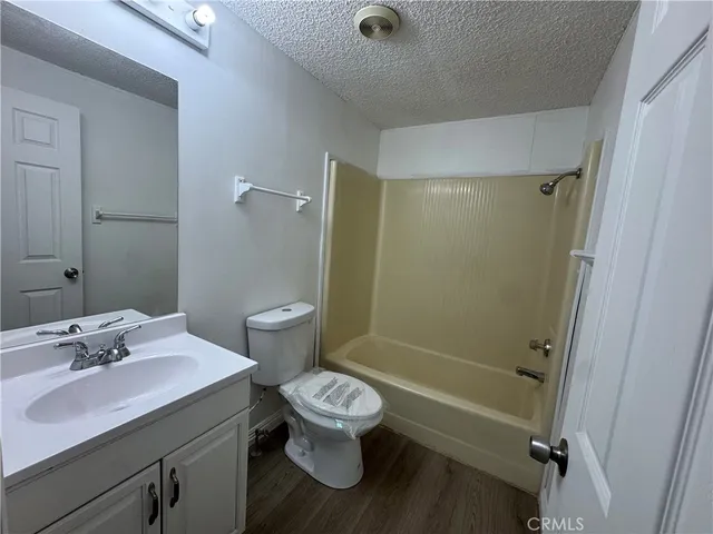 a backyard of a house with table and chairs under an umbrella