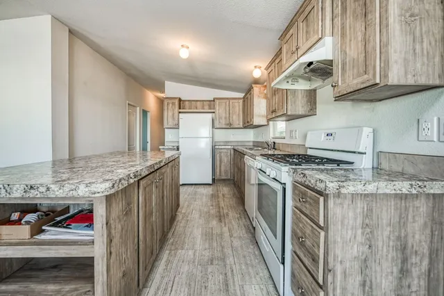 a kitchen with stainless steel appliances granite countertop a stove and a sink