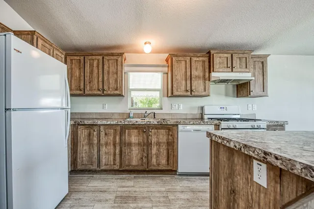 a kitchen with a stove a sink and a refrigerator