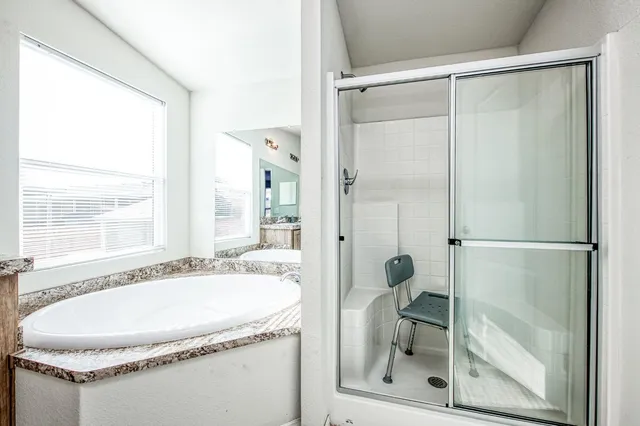 a bathroom with a granite countertop shower and a sink