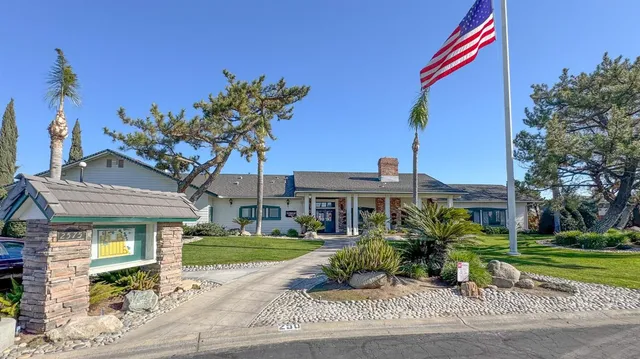 a front view of a house with a yard and potted plants