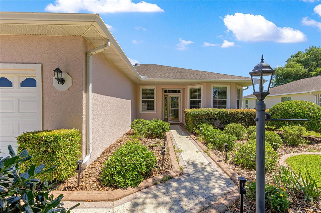 9317 Southwest 94th Loop Ocala, FL 34481 - Photo 2 of 40 a front view of a house with a yard