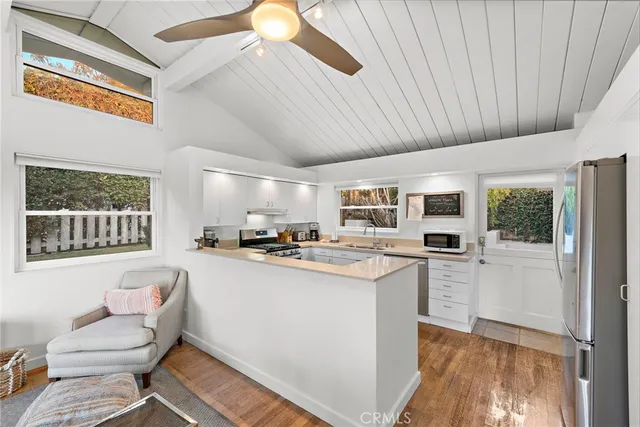 a kitchen with a refrigerator a stove a microwave and white cabinets