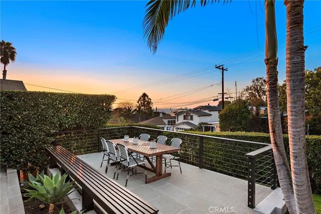 a view of a balcony with chairs and wooden fence