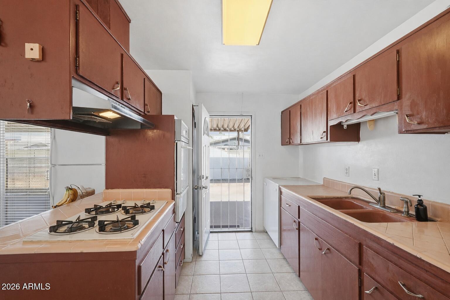 1120 West Romo Jones Street Tempe, AZ 85281 - Photo 9 of 18 a kitchen with a sink stove and cabinets