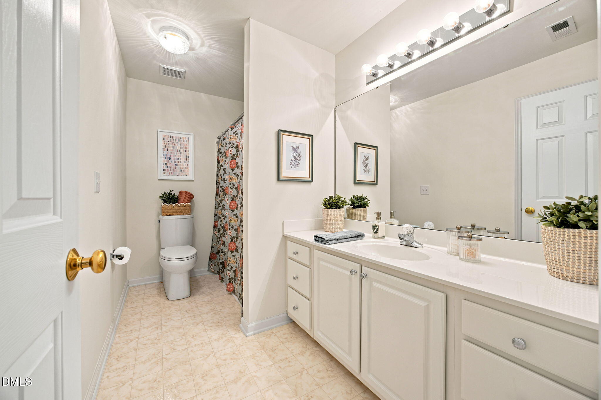 8211 Hempshire Place, Unit 104 Raleigh, NC 27613 - Photo 25 of 34 Bathroom vanity with integrated sink, white cabinetry, and a large wall-mounted mirror