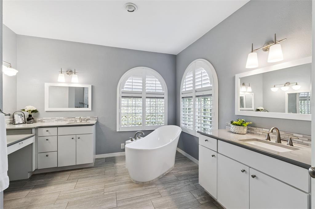 2125 Kane Park Way Windermere, FL 34786 - Photo 24 of 63 a large spacious bathroom with a granite countertop tub a double vanity sink a window and a mirror