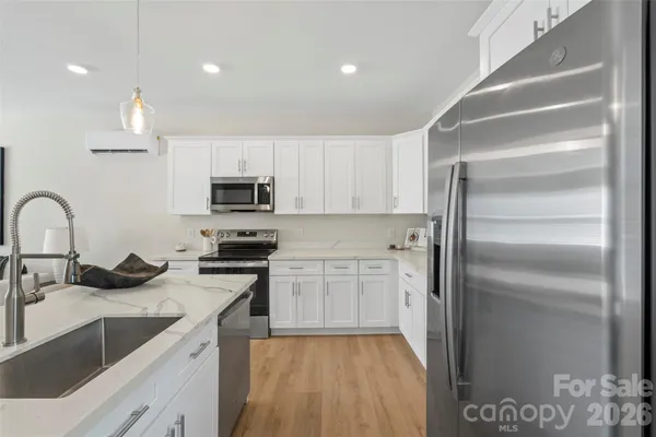 a kitchen with stainless steel appliances granite countertop a sink stove and refrigerator