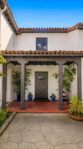 a front view of a house with a garden and a chair