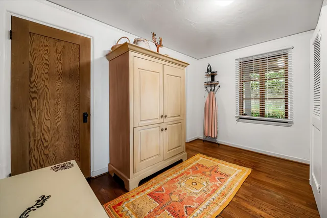a view of a bedroom with wooden floor and windows