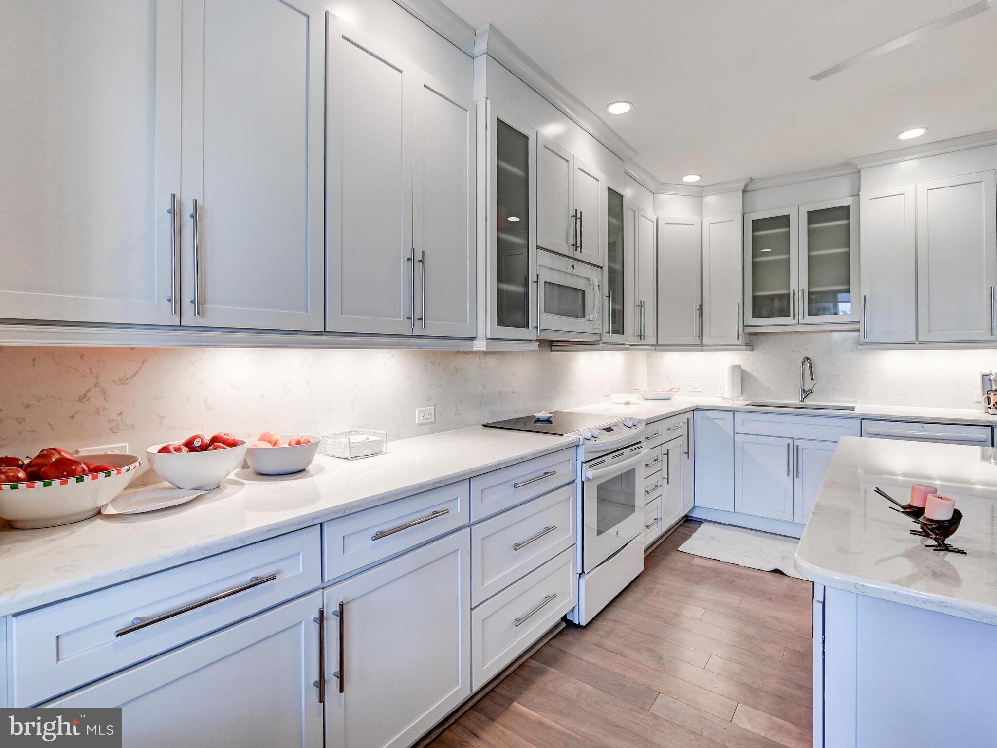 11 Slade Avenue, Unit 410 Pikesville, MD 21208 - Photo 10 of 32 a kitchen with kitchen island granite countertop white cabinets and stainless steel appliances