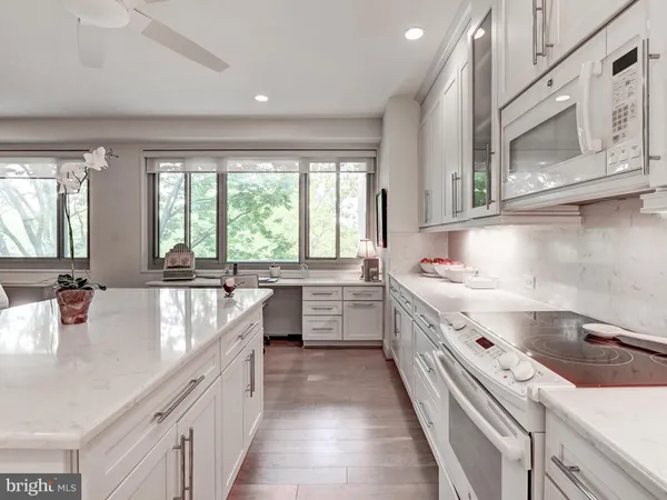 a kitchen with kitchen island granite countertop white cabinets and stainless steel appliances