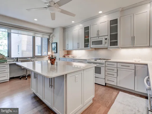 a large white kitchen with a large window