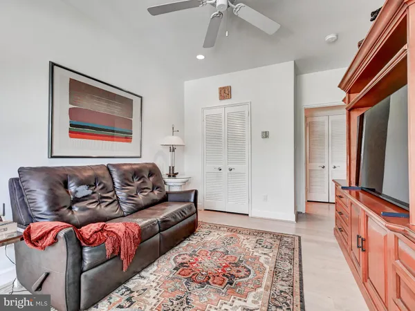 a living room with furniture a flat screen tv and a window