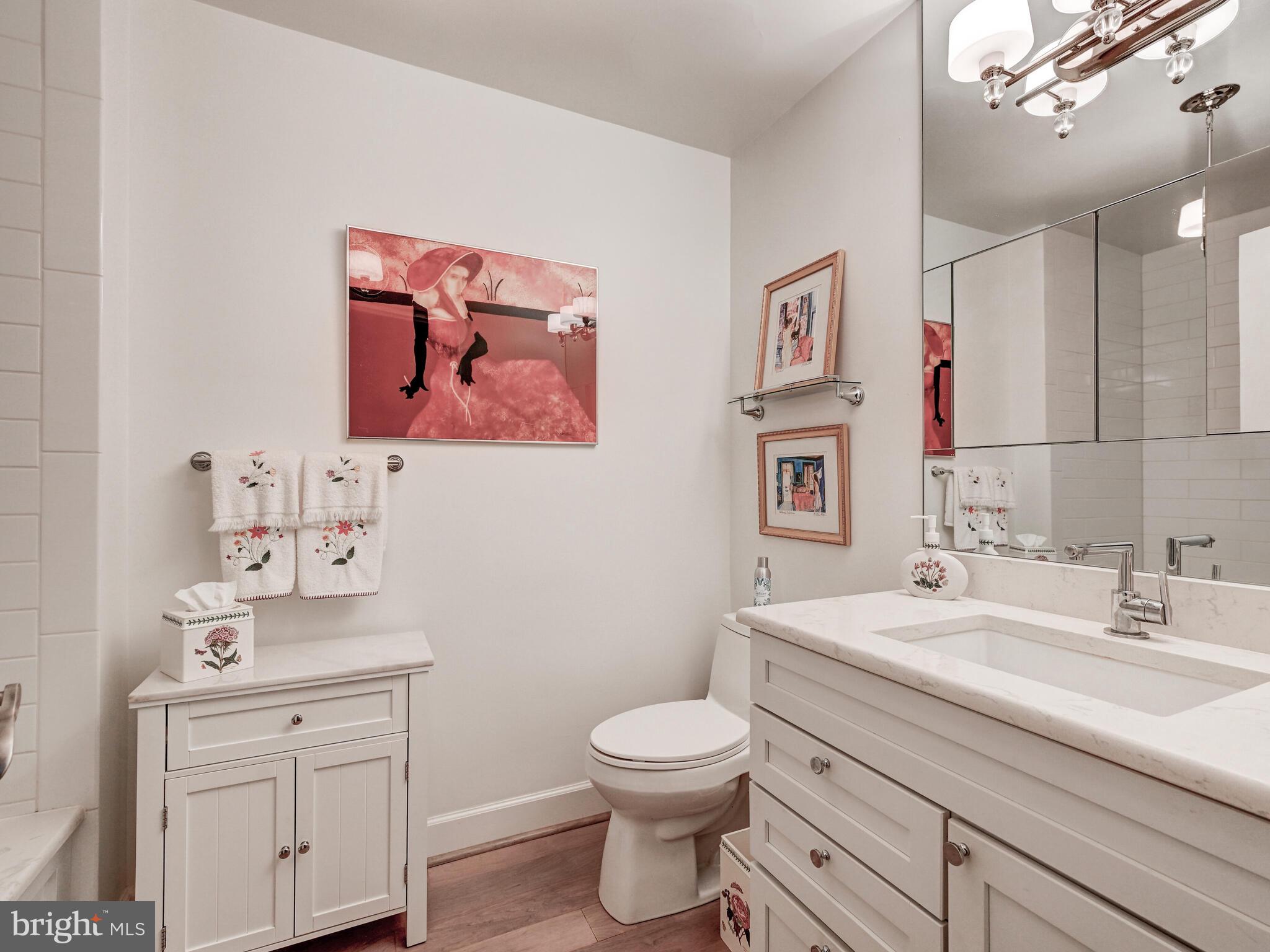 11 Slade Avenue, Unit 410 Pikesville, MD 21208 - Photo 21 of 32 a bathroom with a toilet a sink and mirror
