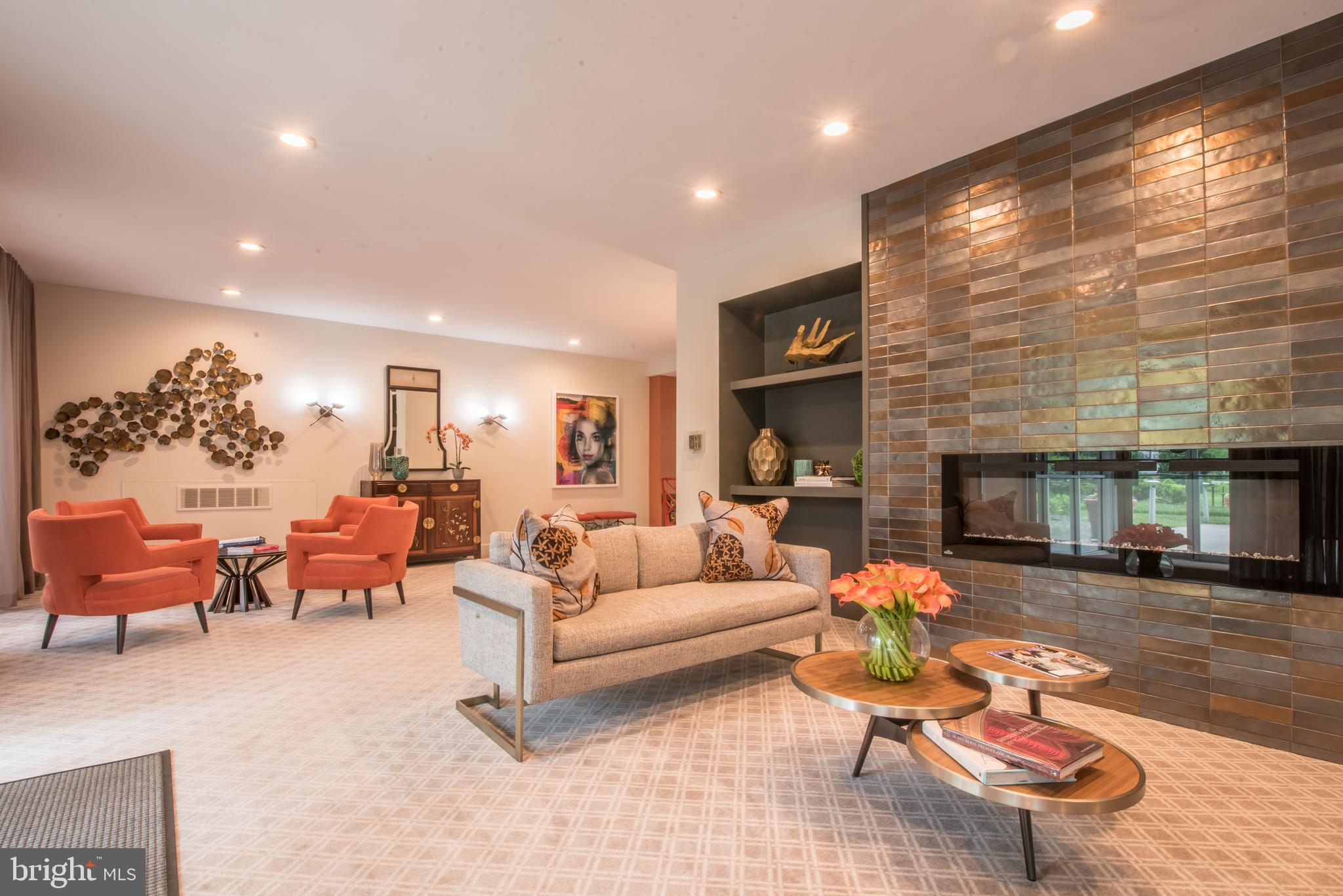 11 Slade Avenue, Unit 410 Pikesville, MD 21208 - Photo 28 of 32 a living room with furniture a fireplace and a flat screen tv