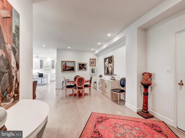 a living room with furniture kitchen view and a wooden floor