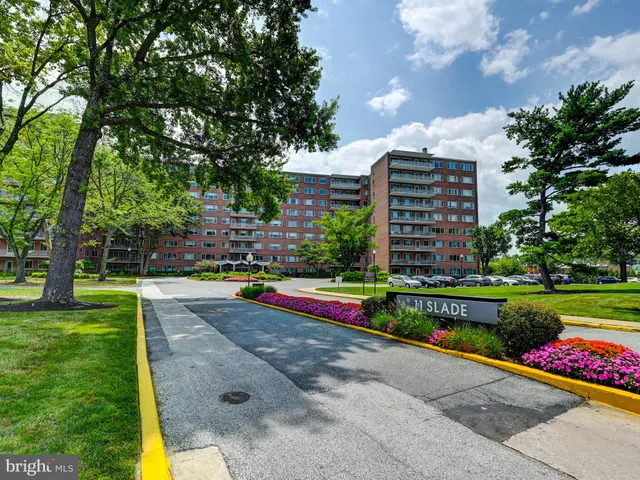 a view of a big building with a big yard and large trees