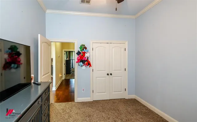 a bedroom with a bed and a flat tv screen on a dresser