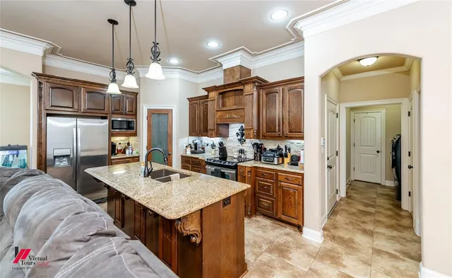 a kitchen with granite countertop a stove a sink a oven and a refrigerator