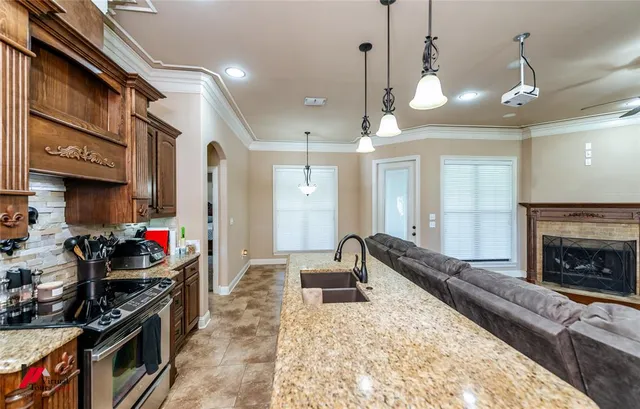 a kitchen with stainless steel appliances granite countertop a sink and a refrigerator