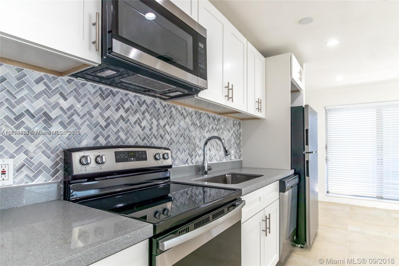 2201 Northeast 14th Avenue, Unit 3 Wilton Manors, FL 33305 - Photo 21 of 27 a kitchen with a stove and a microwave