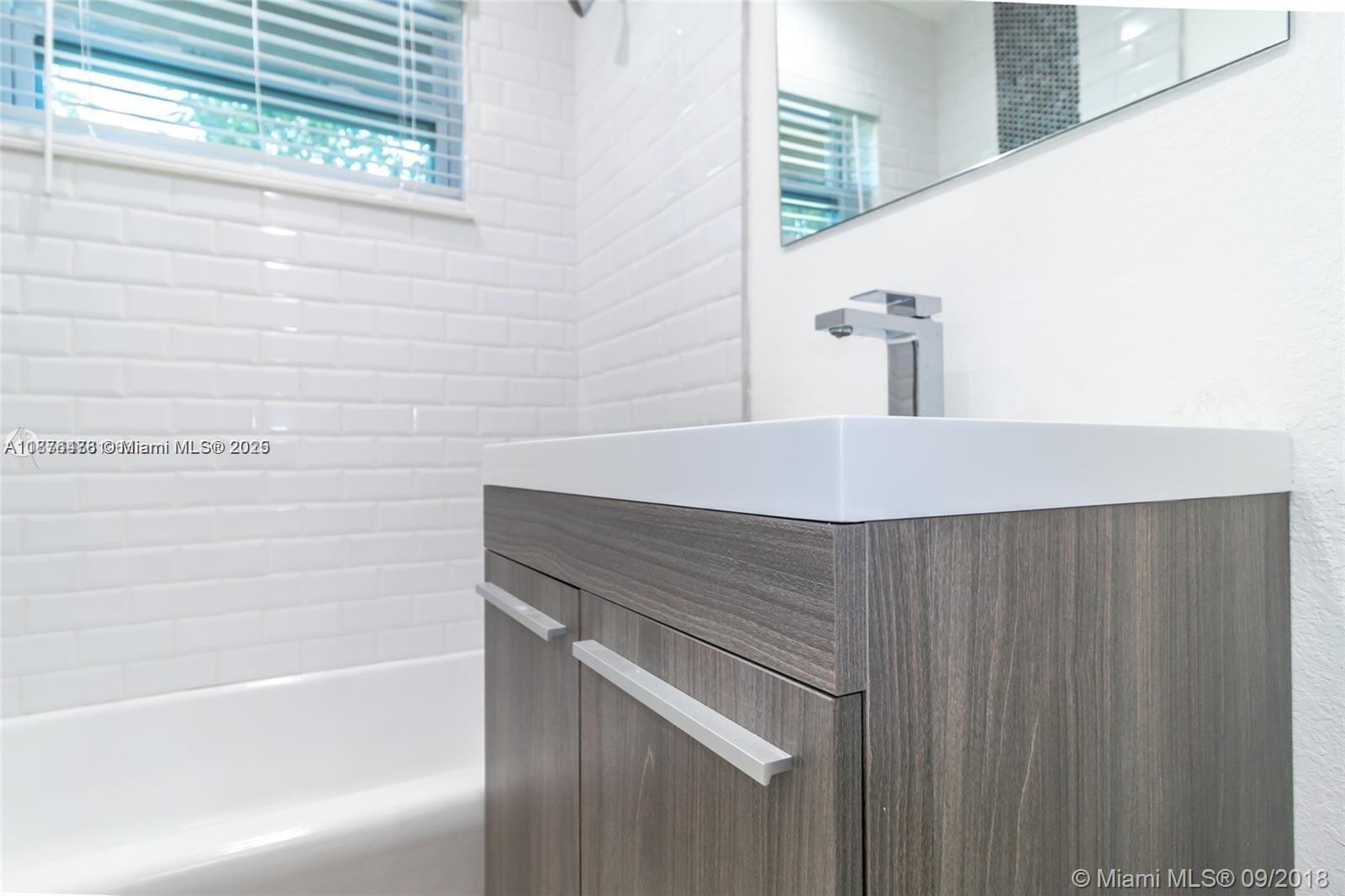 2201 Northeast 14th Avenue, Unit 3 Wilton Manors, FL 33305 - Photo 25 of 27 a bathroom with a sink and a bathtub