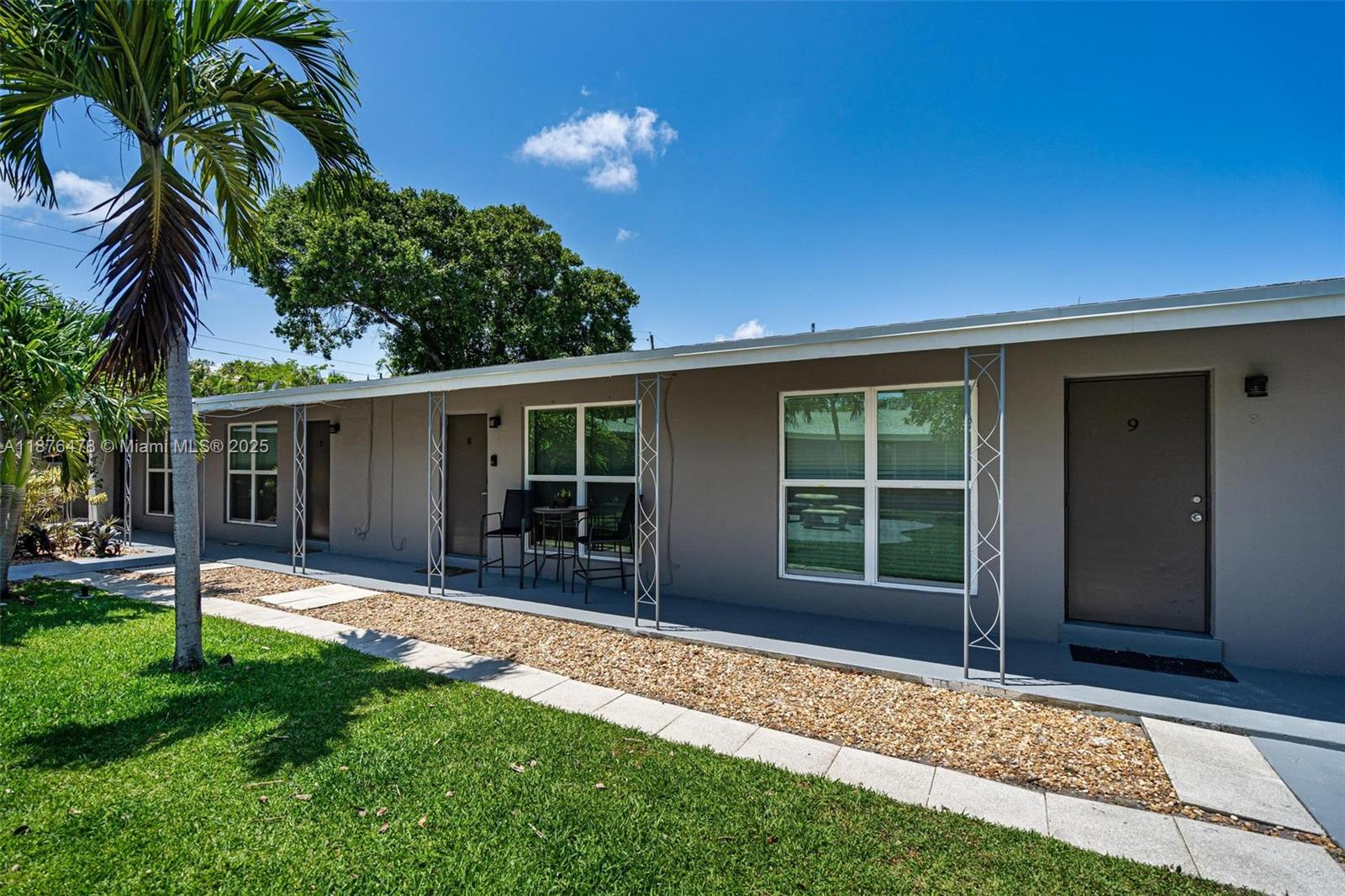 2201 Northeast 14th Avenue, Unit 3 Wilton Manors, FL 33305 - Photo 4 of 27 a front view of a house with a garden and patio