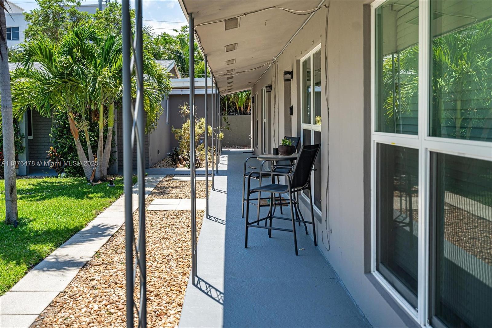 2201 Northeast 14th Avenue, Unit 3 Wilton Manors, FL 33305 - Photo 5 of 27 a view of a patio with table and chairs and floor to ceiling window