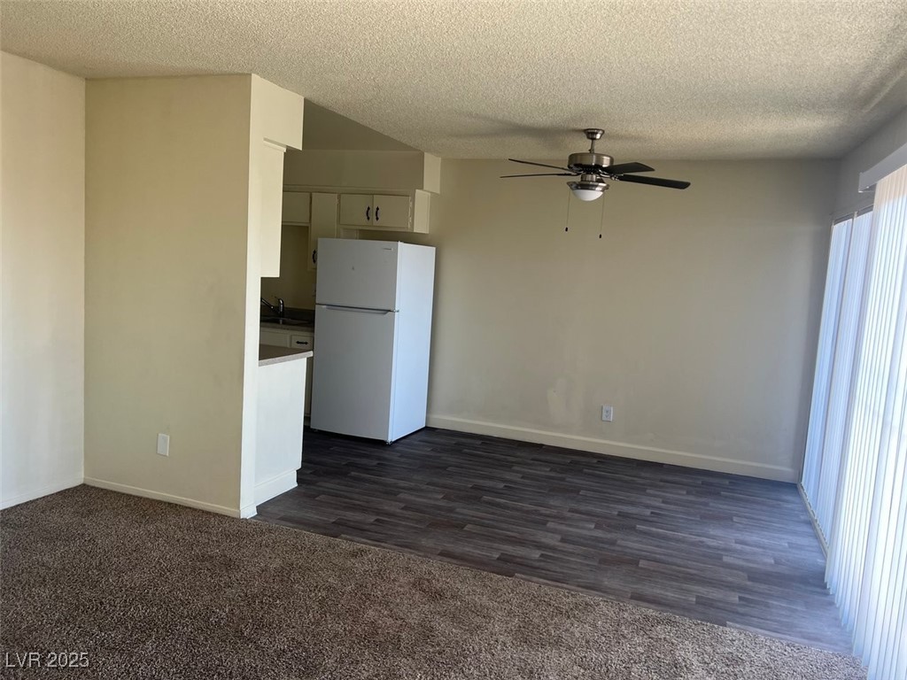 1388 East Desert Inn Road, Unit 1 Las Vegas, NV 89169 - Photo 4 of 17 Kitchen featuring freestanding refrigerator, a ceiling fan, a textured ceiling, baseboards, and dark wood-style flooring