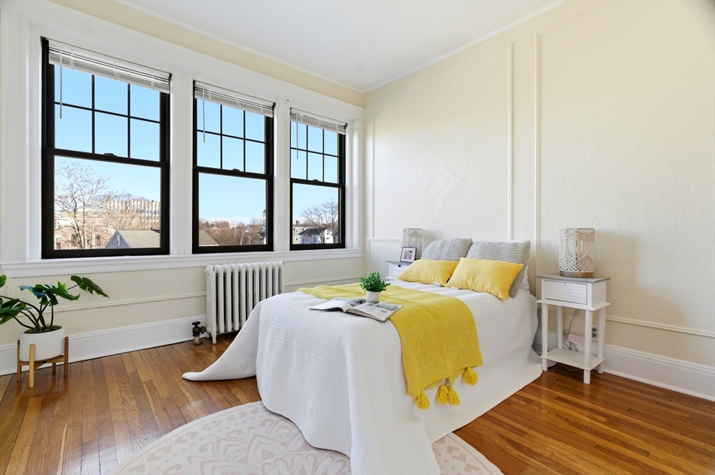 401 Washington Street, Unit 6 Brookline, MA 02446 - Photo 11 of 24 a bedroom with a bed and wooden floor