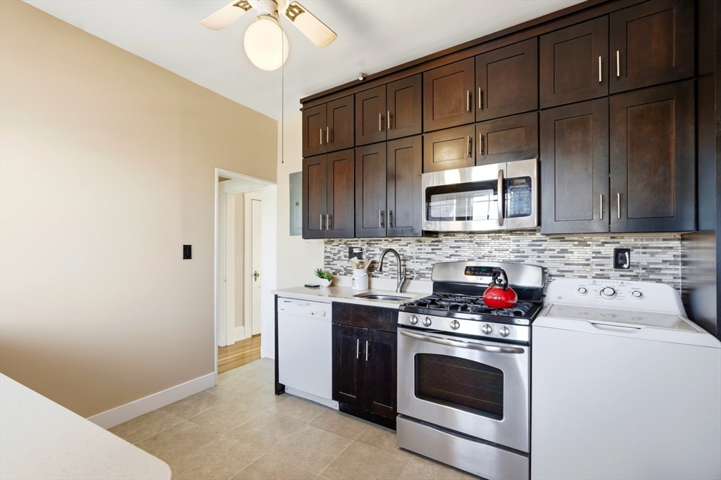 401 Washington Street, Unit 6 Brookline, MA 02446 - Photo 6 of 24 a kitchen with stainless steel appliances granite countertop a sink stove and microwave