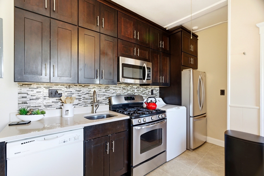 401 Washington Street, Unit 6 Brookline, MA 02446 - Photo 7 of 24 a kitchen with stainless steel appliances granite countertop a refrigerator stove and sink