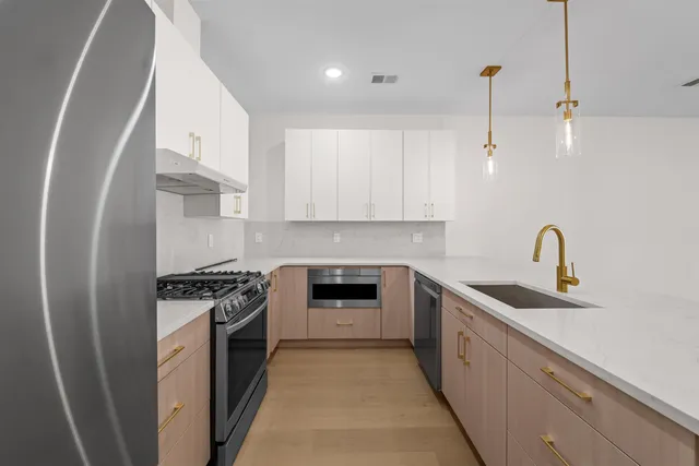 a kitchen with stainless steel appliances granite countertop a stove sink and cabinets