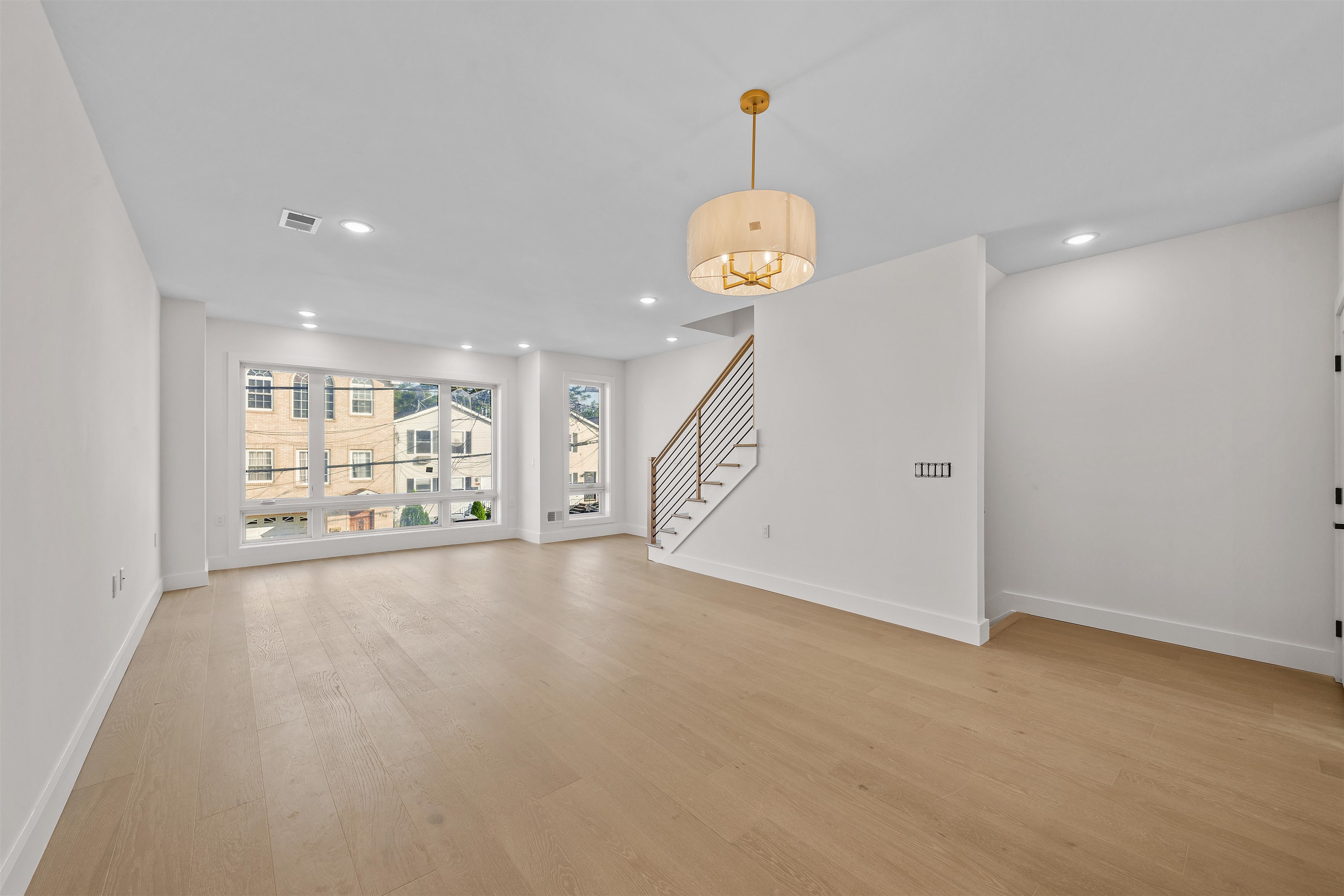 249.5 Halladay Street, Unit 2 Jersey City, NJ 07304 - Photo 6 of 36 a view of an empty room with wooden floor and a window