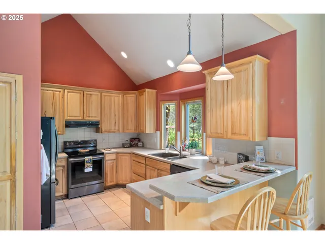 a kitchen with stainless steel appliances granite countertop a refrigerator stove and sink