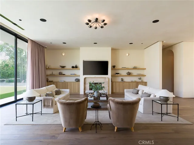 a large white kitchen with a window and stainless steel appliances