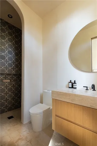 a en suite bathroom with a granite countertop sink and a mirror